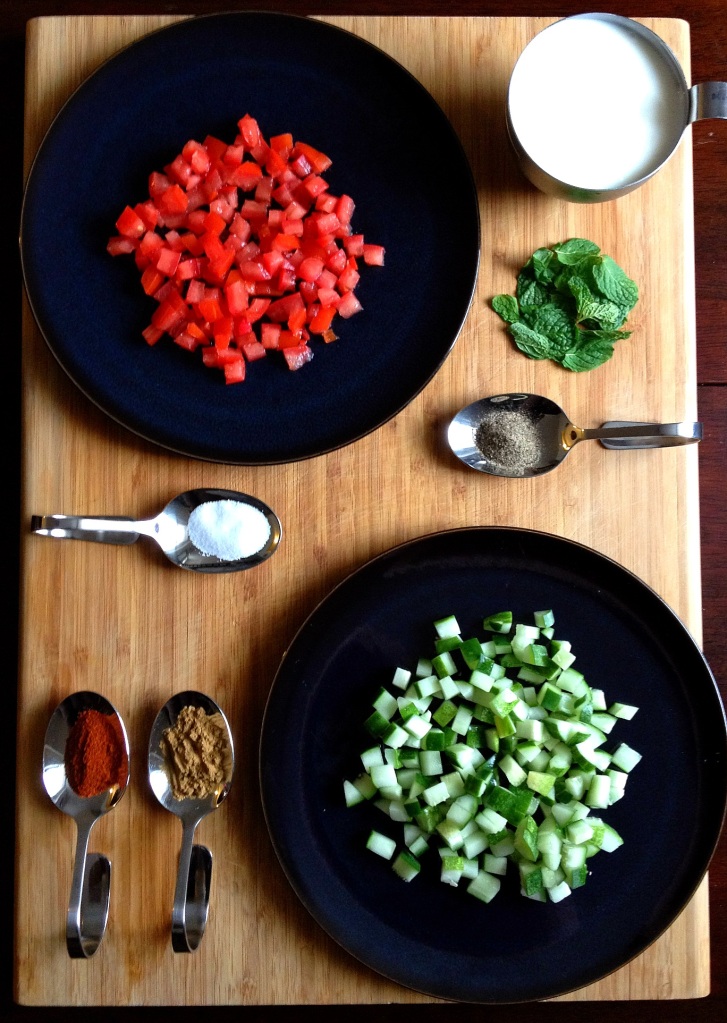 Ingredients for Indian Raita: seeded and diced tomato, plain yogurt, fresh mint leaves, pepper, salt, paprika, cumin, seeded and diced cucumber