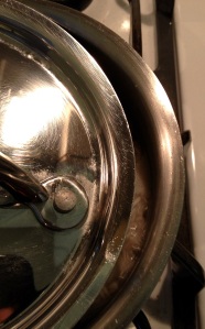 Cooking basmati rice in a small saucepan on the stovetop with lid half closed