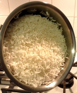 Rice almost cooked in a small saucepan on the stovetop