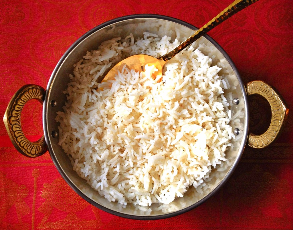 Cooked basmati rice in a copper pot on beautiful red tablecloth
