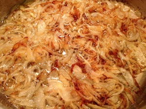 Browning sliced onions in hot oil on stovetop