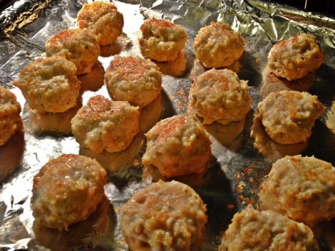 Half-cooked meatballs on a foil-lined sheet in oven