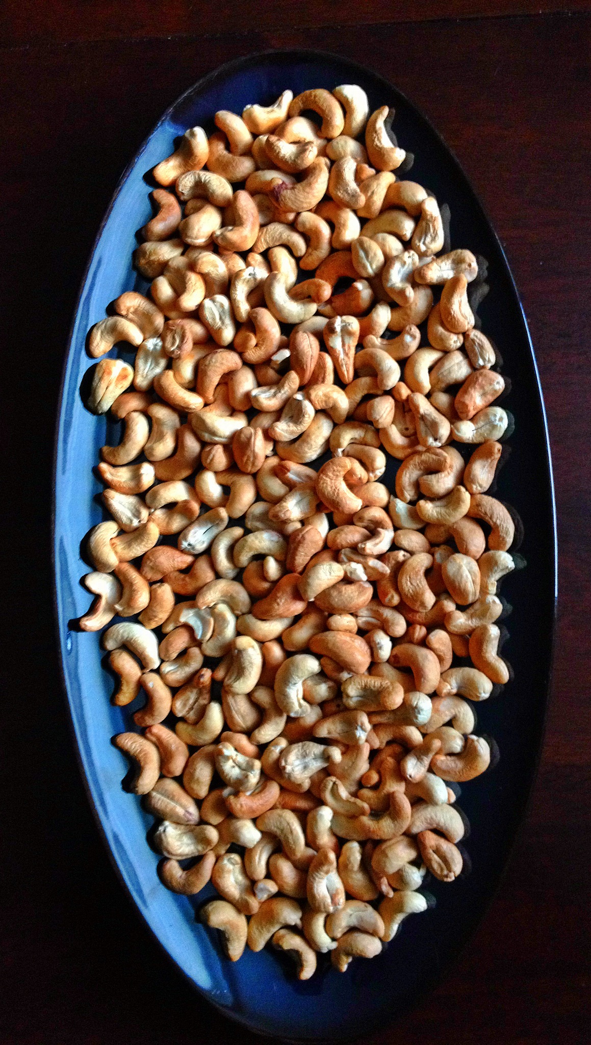 Oven-roasted cashews cooling on a platter