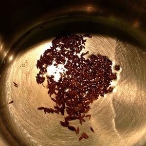 Heating oil and cumin seeds in a saucepan