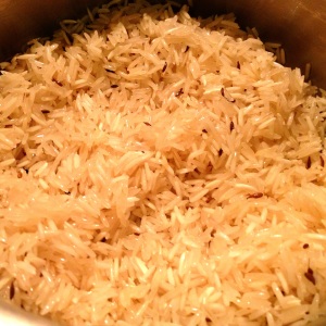 Raw basmati rice in a saucepan with oil and cumin seeds
