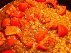 Adding tomatoes to Baingan Burtha (Eggplant Curry)