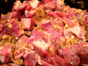 Adding boneless, skinless lamb to onion and spices