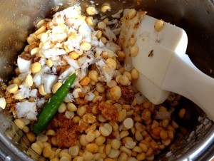Grinding raw coconut pieces together with dale, green chilli, tamarind juice and brown sugar