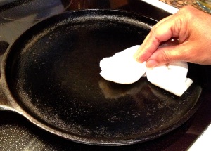 Coating a cast iron pan with oil for masala dosa